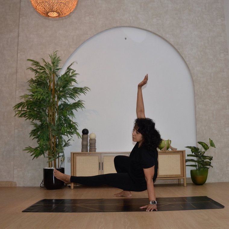Shipra in a low side lunge with one arm raised